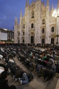 People kneel down in prayer in front of Milan's gothic cathedral as they protest Israeli airstrikes in Gaza, during a demonstration in Milan, Italy, Saturday, Jan. 3, 2009. Several hundred people, many of them draped in the Palestinian flag, walked through downtown streets, and at least one Israeli flag was burned, during a protest late Saturday afternoon. (AP Photo/Luca Bruno)